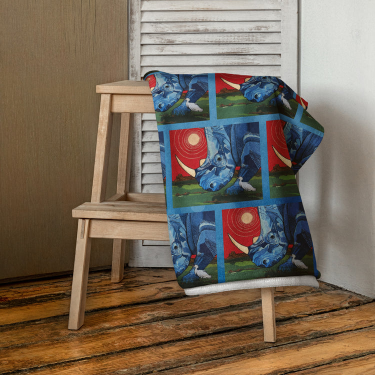 Towel hanging on a stool with tile pictures of a blue Rhinoceros with a red sky