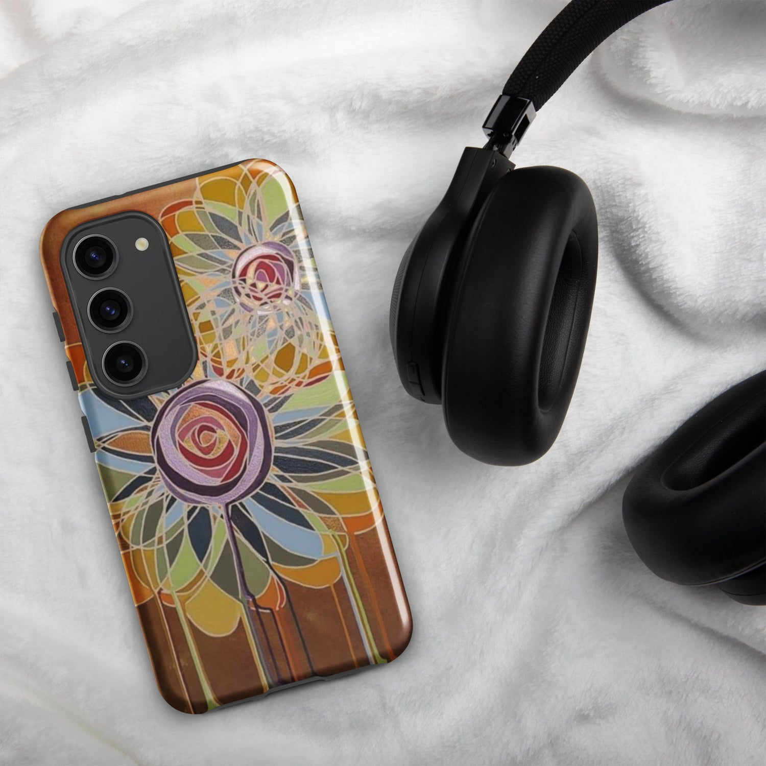 Cell phone cover with gold background and a multicolored swirl flower