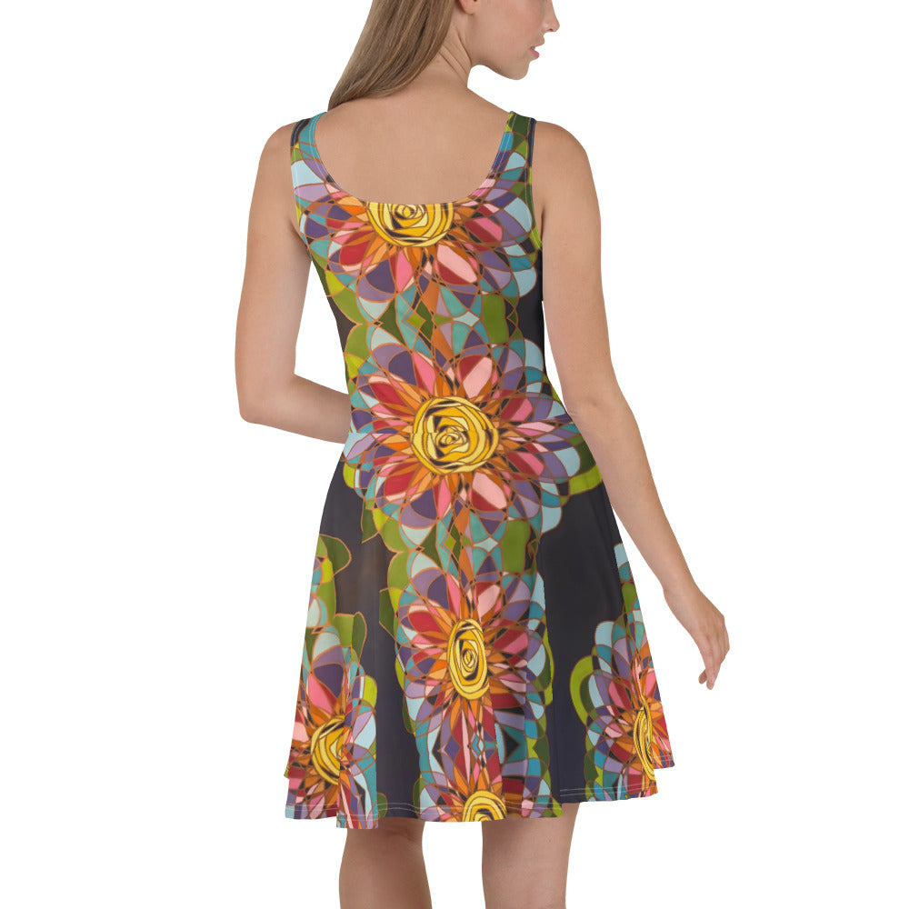 Bonde woman in a sleeveless dress, cut above the knees, designed with large swirl flowers in the colors of the spectrum.