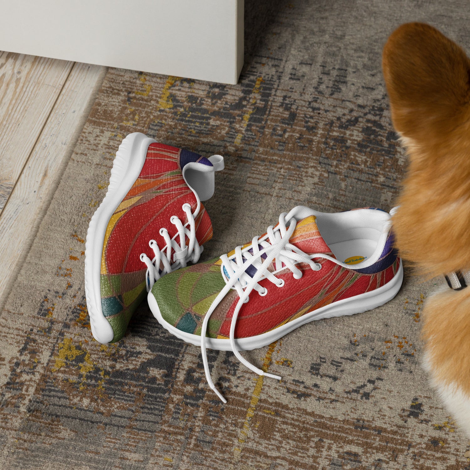 Athletic shoes lying on the floor next to a dog